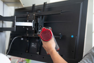 Cropped hand of man cleaning television set