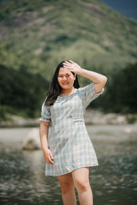 Young woman standing against waterfall