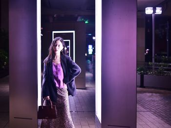 Woman looking at illuminated camera at night