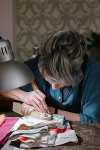 Midsection of woman sitting on table