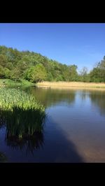 Scenic view of lake against clear blue sky