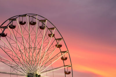 Low angle view of ferris wheel against sky during sunset