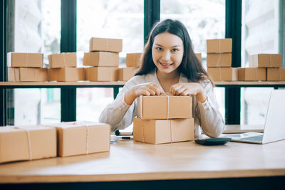 Portrait of a smiling young woman using phone