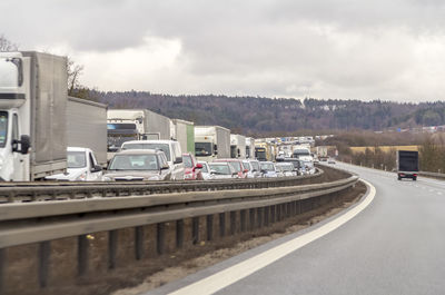 Cars on road against sky in city