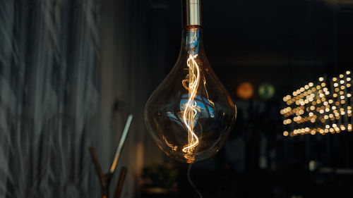Close-up of light bulb hanging at night