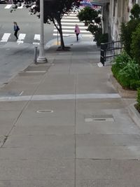 People walking on footpath in city