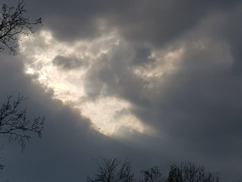 Low angle view of bare tree against cloudy sky