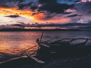 Scenic view of sea against dramatic sky during sunset