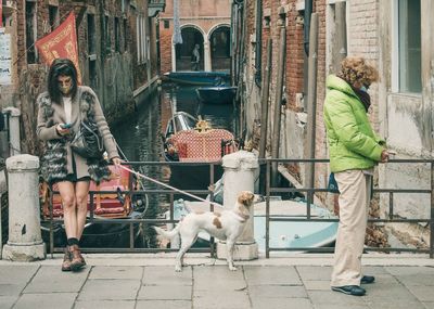 People with dog in front of building