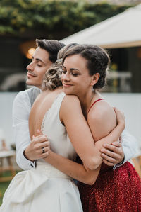 Woman embracing with bridegroom outdoors