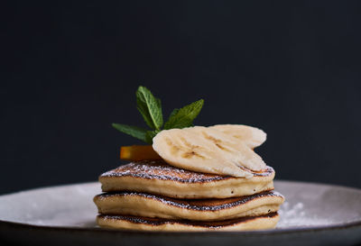 Close-up of cake on table against black background