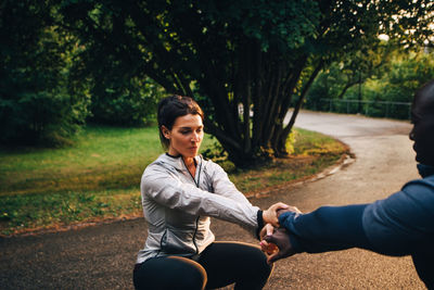 Full length of couple sitting on tree