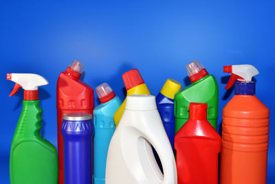 Close-up of multi colored bottles against blue background