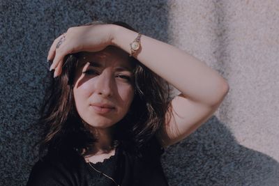 Portrait of young woman against wall