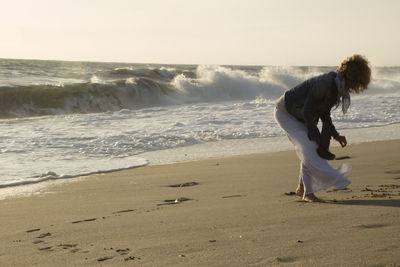 Woman standing on beach against sea