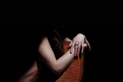 Low section of woman standing against black background