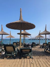 Chairs on beach against clear sky