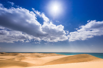 Scenic view of sand dunes against sky