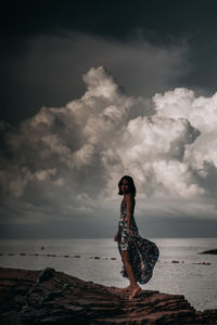 Full length of woman standing on beach against sky