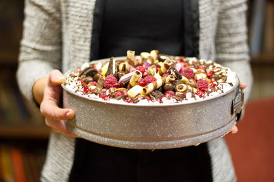 Midsection of woman holding decorated cake