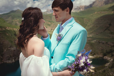 Love, wedding and married couple kissing by the lake outdoors in honor of their romantic marriage