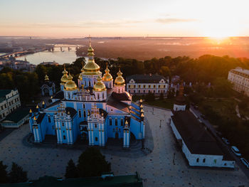 High angle view of trees and buildings against sky during sunset