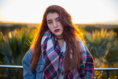 Portrait of beautiful young woman standing against clear sky