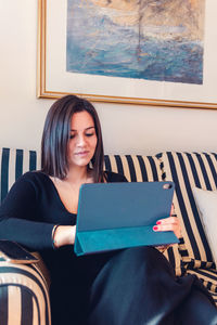 Young woman sitting on chair at home