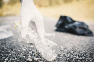 Cropped hand collecting waste on road