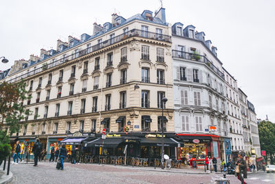 Group of people on street against buildings