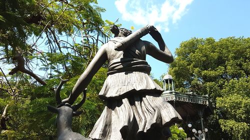 Low angle view of statue against trees