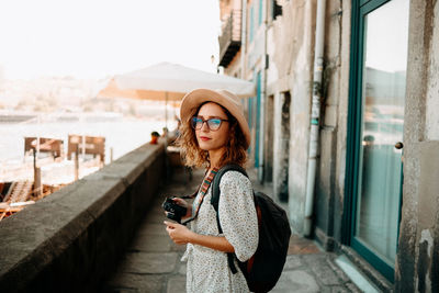 Portrait of woman standing on mobile phone in city