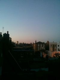 Buildings against clear sky at sunset