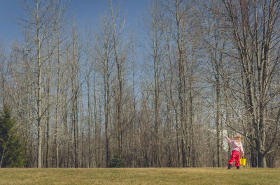 Full length of girl on tree against sky