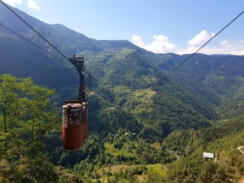 Overhead cable car on mountains against sky