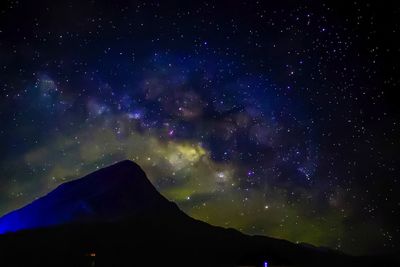 Low angle view of silhouette mountain against star field