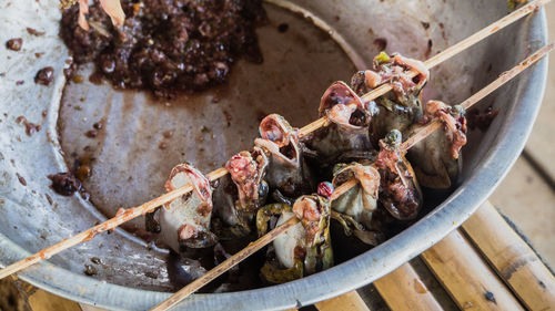 High angle view of frogs in skewers on container