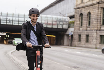 Businessman riding e-scooter in the city