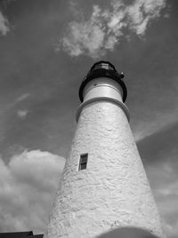 Low angle view of lighthouse by building against sky