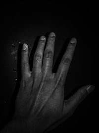 Close-up of human hand against black background