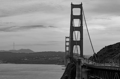 Suspension bridge over sea against sky