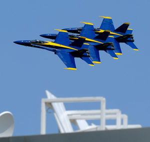 Low angle view of airshow flying against sky