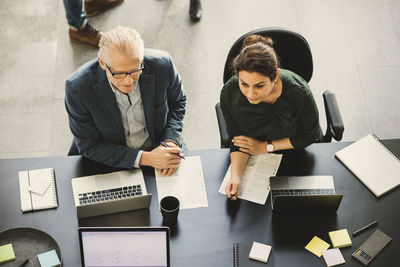 High angle view of business people at table during meeting in creative office