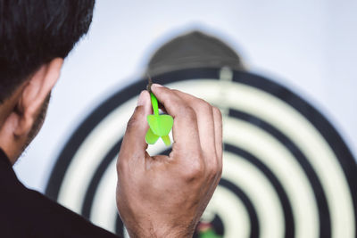 Cropped image of man holding dart