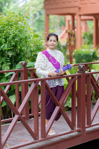 Portrait of woman sitting on railing