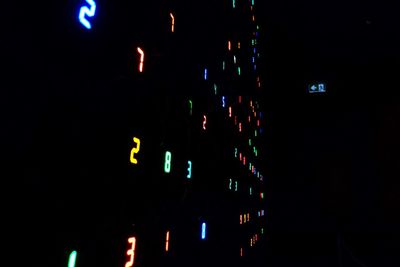 Low angle view of illuminated lights against sky at night