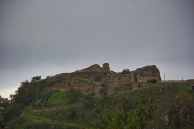 Low angle view of castle on mountain against sky