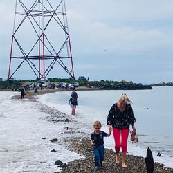 People on sea shore against sky