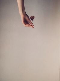 Low section of woman hand against white background