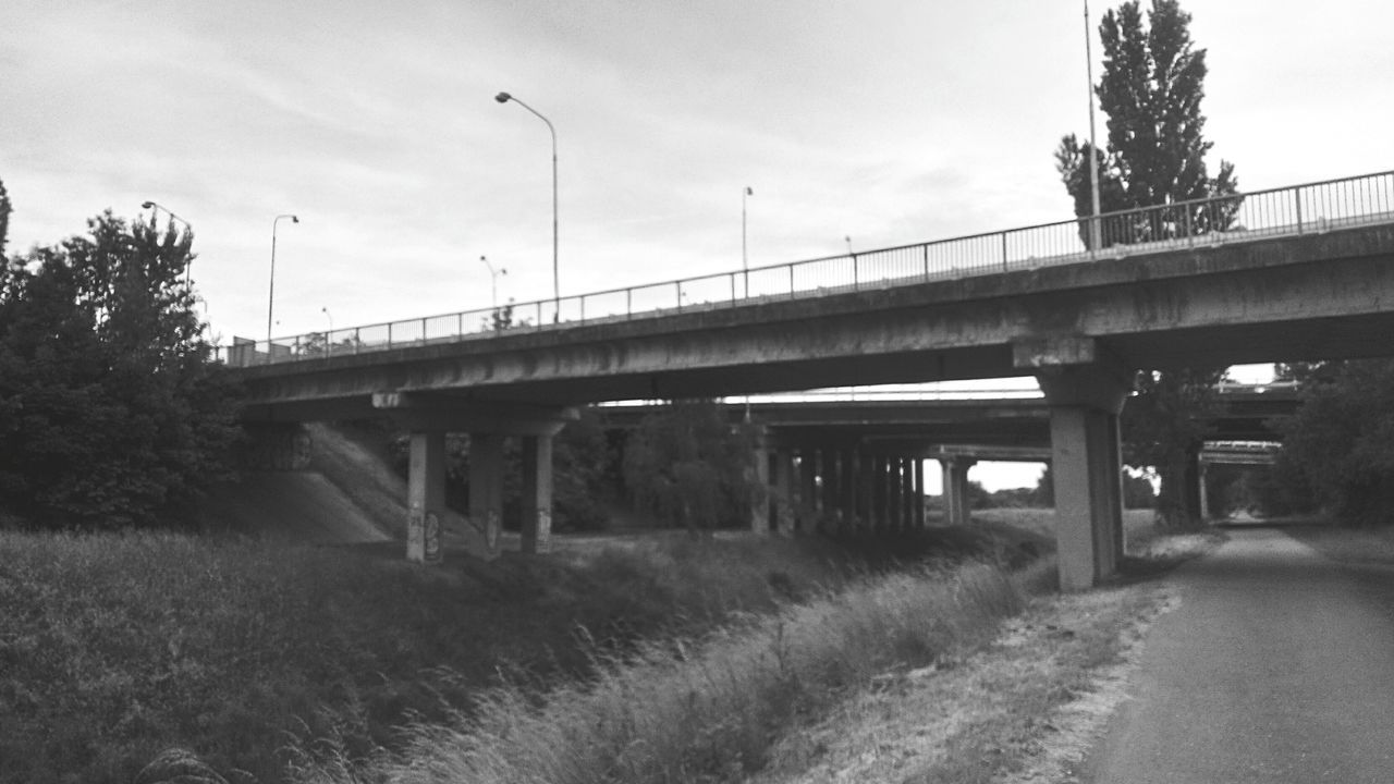 transportation, connection, bridge - man made structure, built structure, architecture, sky, engineering, railroad track, rail transportation, tree, road, bridge, the way forward, cloud - sky, public transportation, train - vehicle, outdoors, no people, long, day